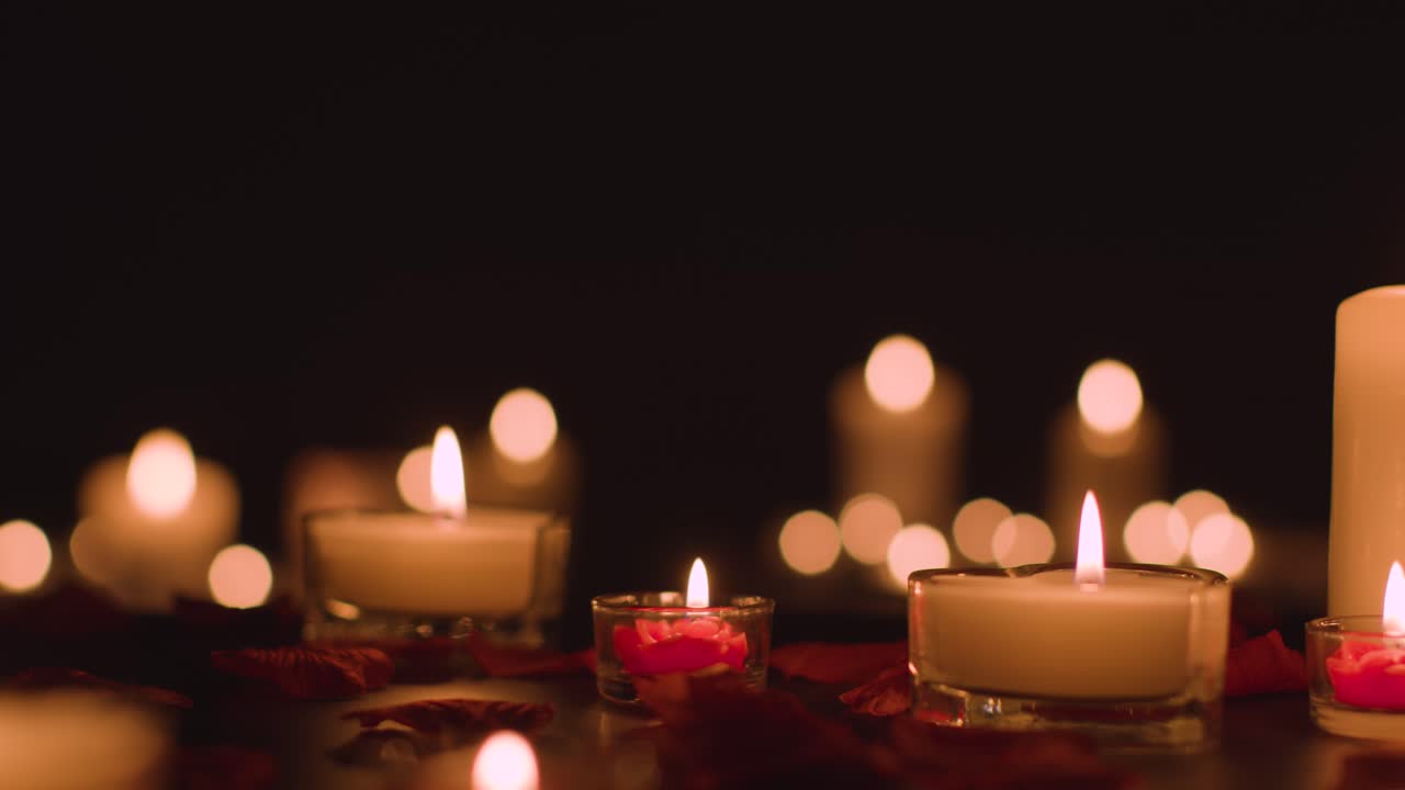 Free stock video - Eye level shot of romantic lit candles on black